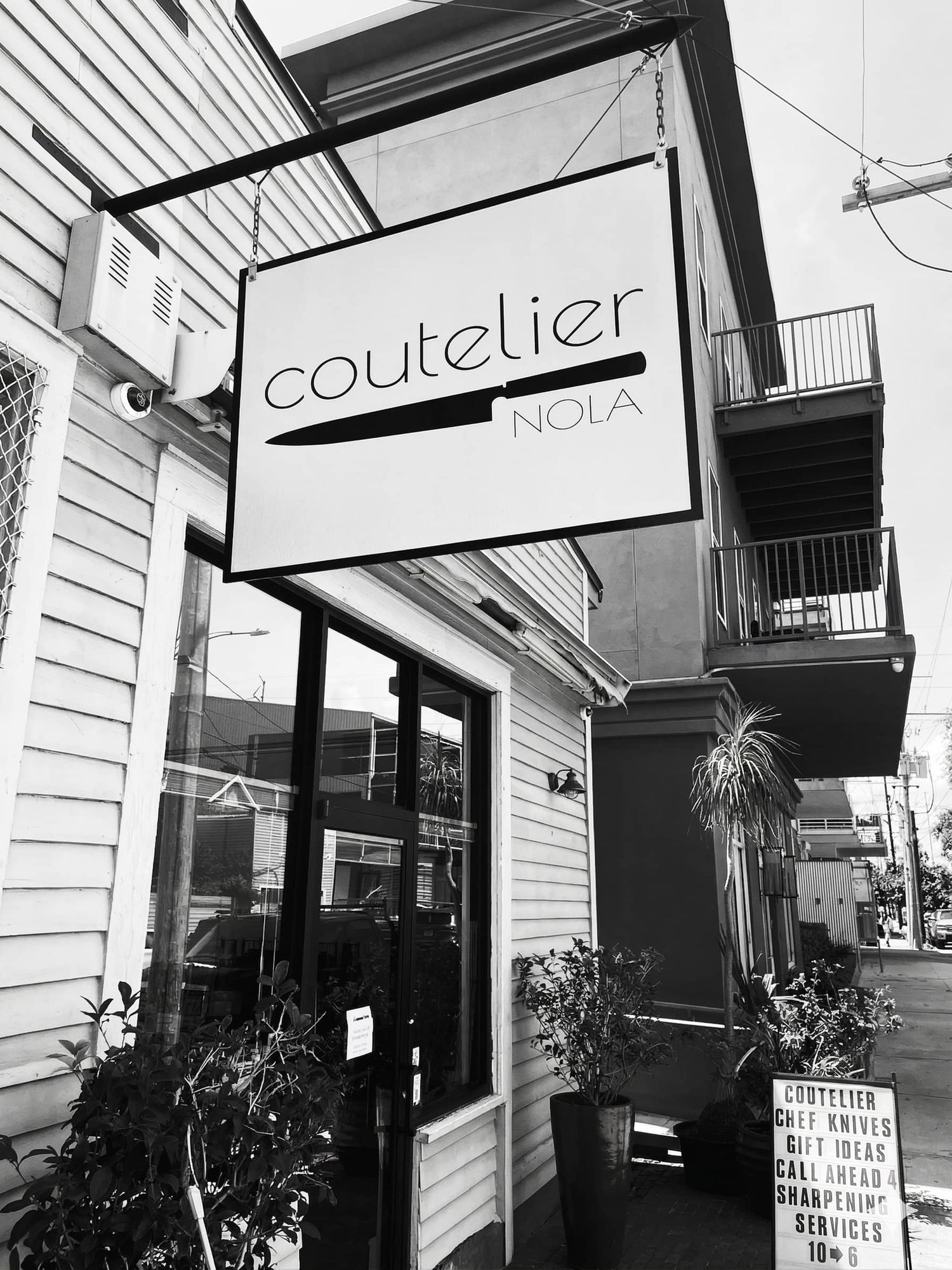 Black and white exterior of a building with 'coutelier' sign.